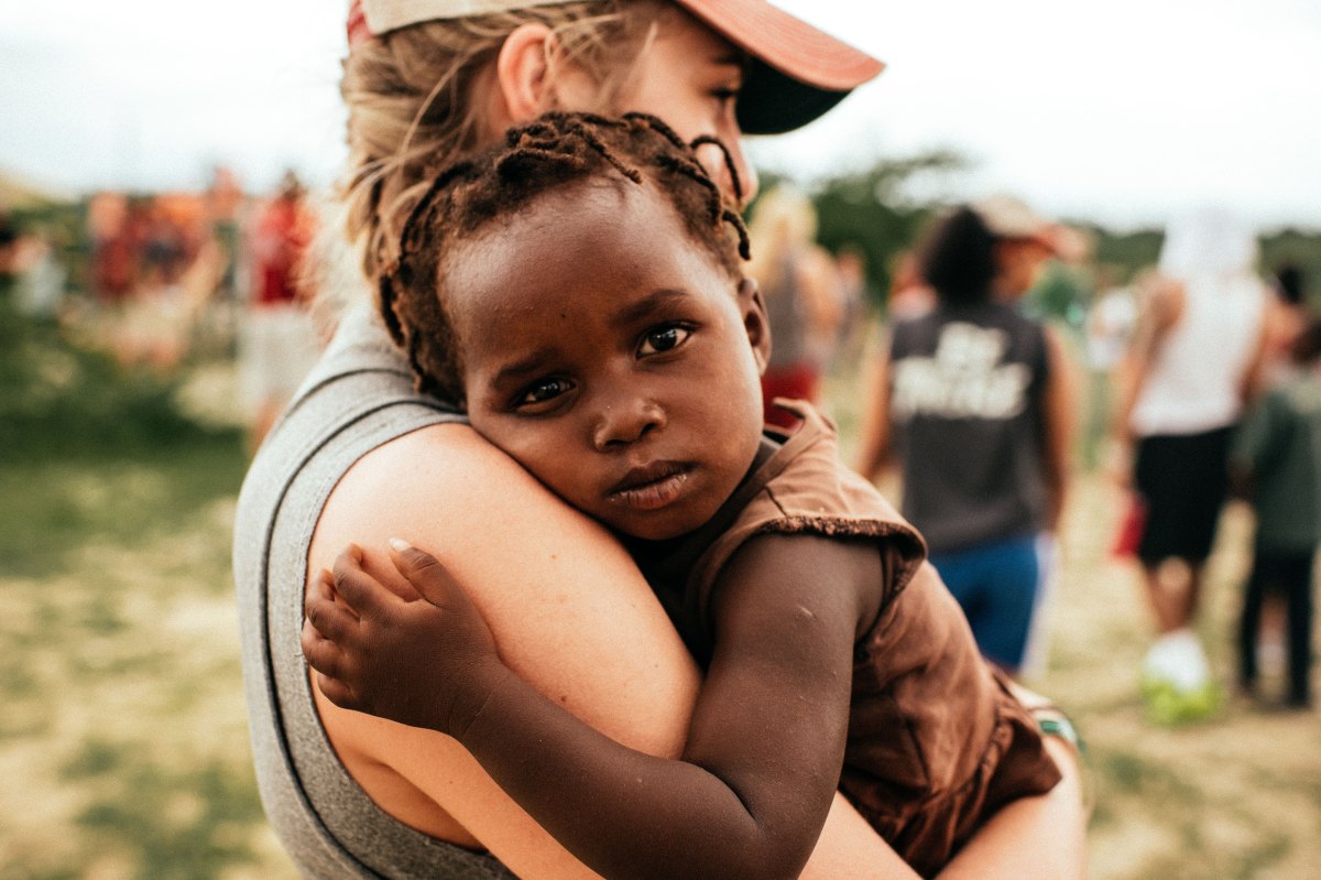 Young woman holding Haitian child.