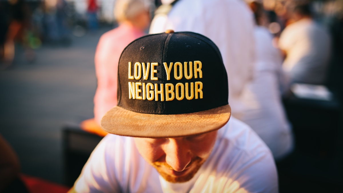 Young man wearing hat that says Love Your Neighbor.